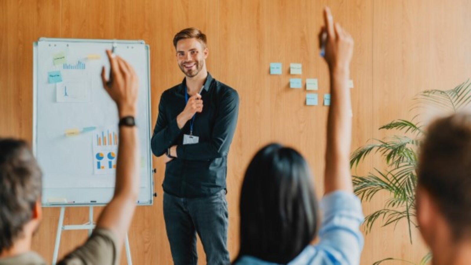 Por qué es importante el coaching organizacional; Joven dando una plática a un equipo de trabajo.